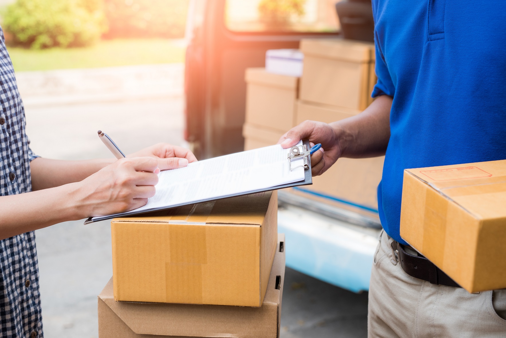 Close up hands accepting a delivery of boxes from deliveryman